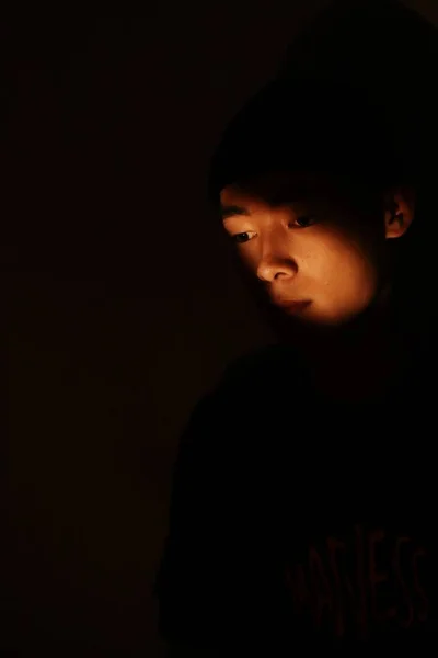 portrait of a young man in a black t-shirt on a dark background