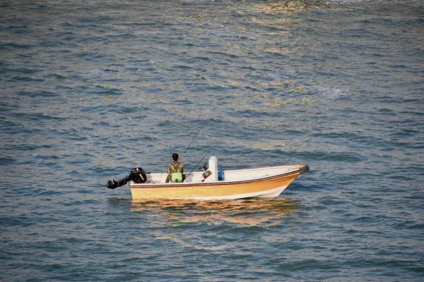 a man in a boat is fishing on the beach