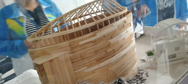 a woman is holding a wooden basket in a shop