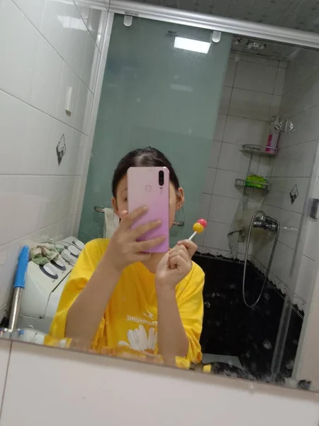 young woman washing her face with a mask in the bathroom