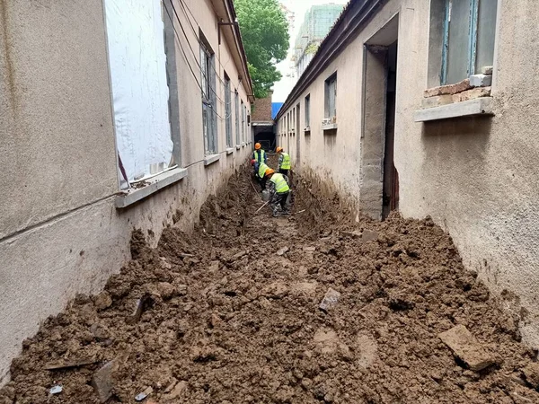 worker in a protective helmet is working on a dirt road