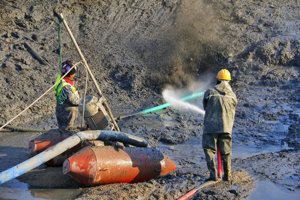 worker in protective helmet and gloves working on the ground