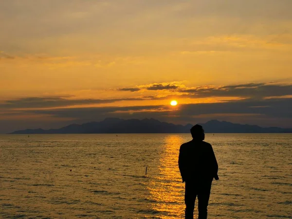 silhouette of a man with a backpack on the beach