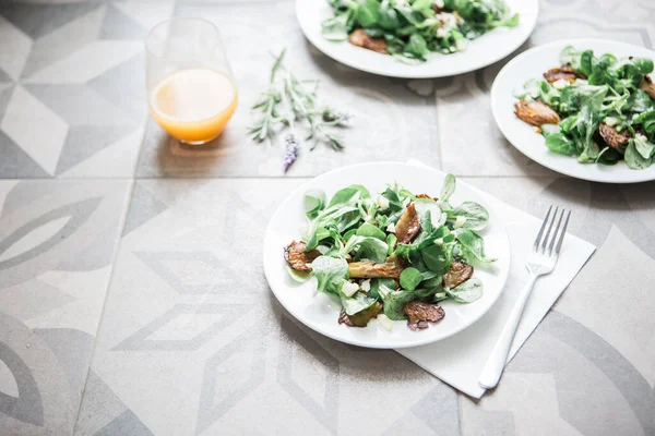 salad with arugula and green leaves on a white plate