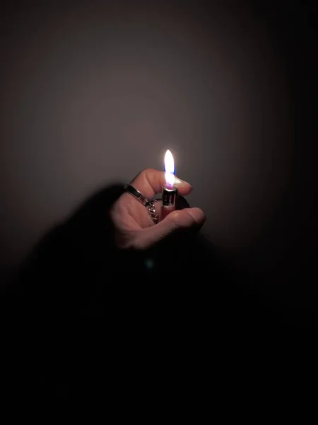 burning candle in the hands of a woman