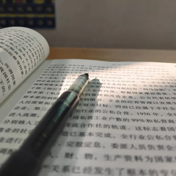 close up of a book with a pen