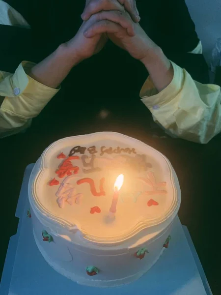 candle in the hands of a woman in a white robe