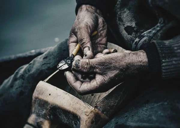 man\'s hands with a tattoo in the workshop
