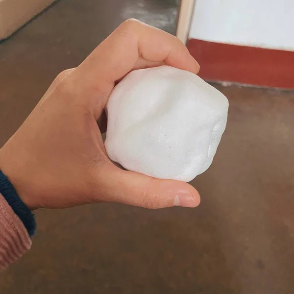 hand holding a white sponge with a brush