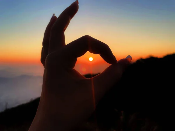 hand holding a heart in the sky