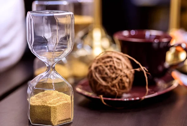 glass of wine and a clock on a table