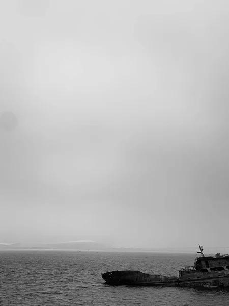 black and white photo of a beautiful sea with a cloudy sky