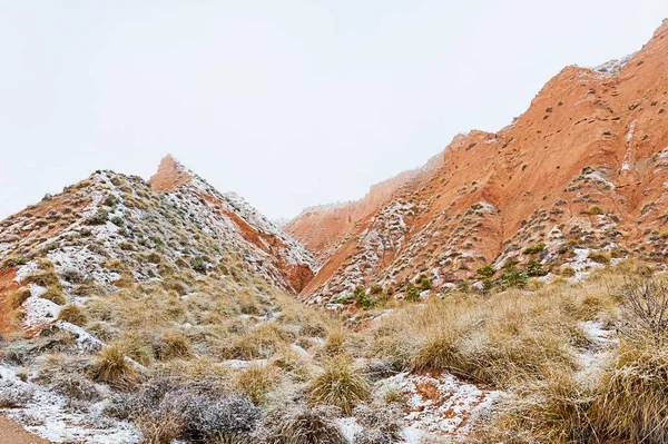 Partially snow-capped brown mountains against a dark blue sky — Stock Photo, Image