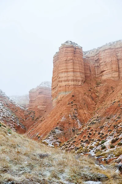 Montagne brune parzialmente innevate contro un cielo blu scuro — Foto Stock