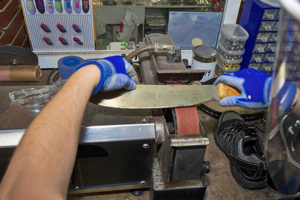 Молодий взуттєвик ремонтує взуття в ремонтному магазині . — стокове фото