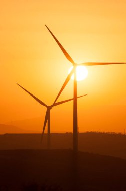 Rüzgar türbinlerinin arkasında muhteşem bir günbatımı.