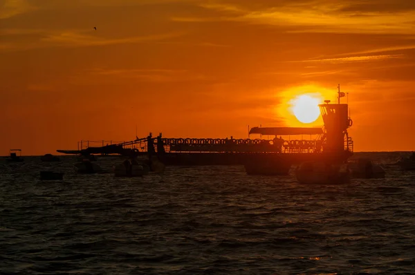 Zachód słońca za rzecznymi łodziami rybackimi. — Zdjęcie stockowe