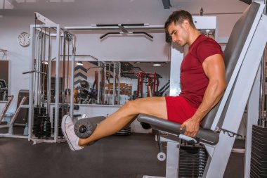 Fitness makinesinde bacak geliştirme eğitimi.
