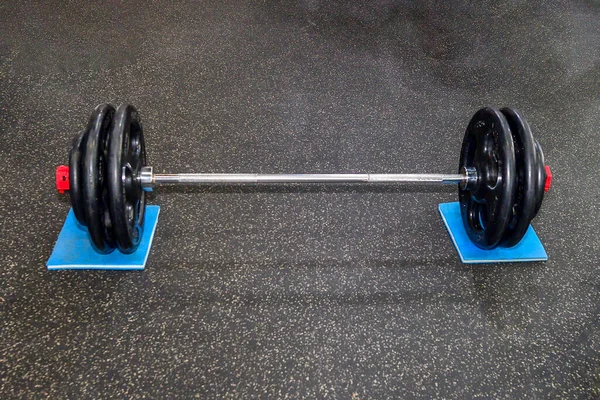 Isolated gym barbell perched on the floor. — Stock Photo, Image