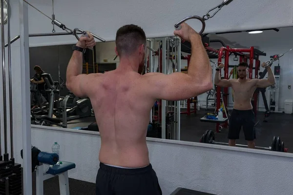 Junge trainiert seinen Bizeps in der Turnhalle. — Stockfoto