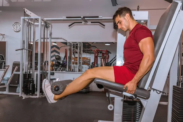 Prodloužení nohou trénink na fitness stroje. — Stock fotografie