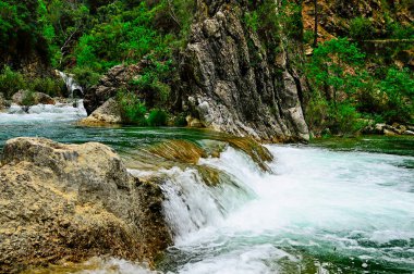 Kalıcı olarak akan doğal su nehri.