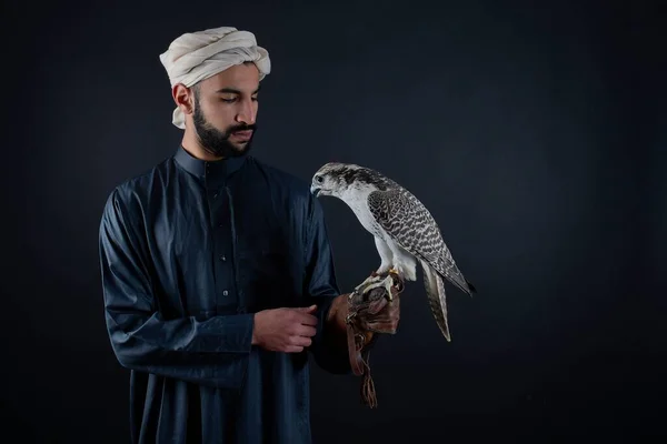Jovem falcoeiro segurando um pássaro de rapina. — Fotografia de Stock