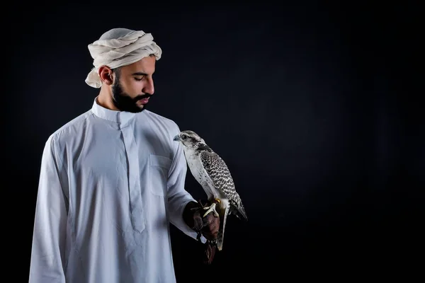 Jovem falcoeiro segurando um pássaro de rapina. — Fotografia de Stock
