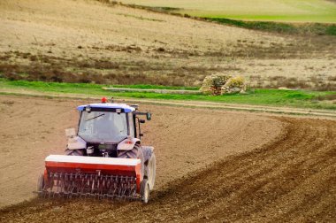 Traktör tarımda çalışıyor.