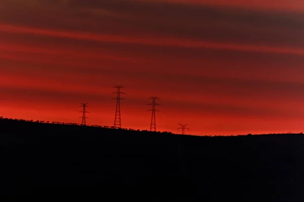 Zonsondergang boven de bergen beplant met elektrische windturbines — Stockfoto