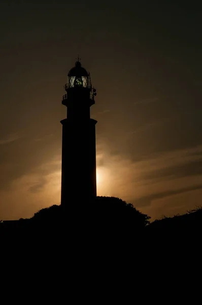 A lighthouse or light signaling tower located on the sea coast or on the mainland. — Stock Photo, Image