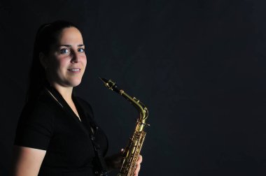Young girl plays jazz music on saxophone