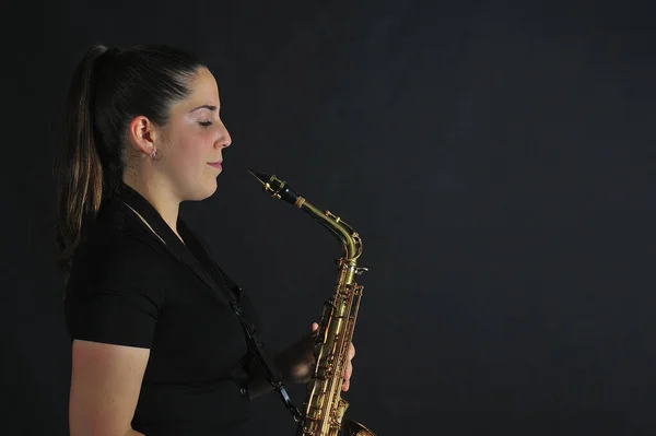 Young girl plays jazz music on saxophone — Zdjęcie stockowe