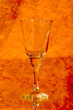 Yansıtıcı bir yüzeyde boş şarap kadehi..