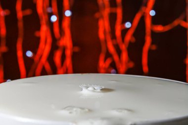 Damlalar sahte arkaplanlı bir konteynırın üzerine düşüyor.