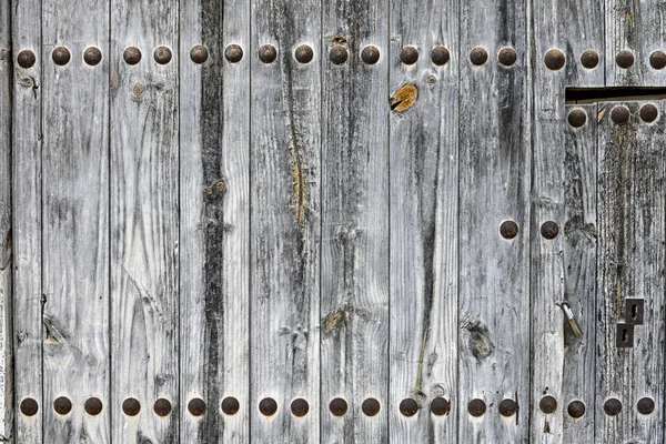 Stare i wietrzne drewniane drzwi w wiejskim miasteczku — Zdjęcie stockowe
