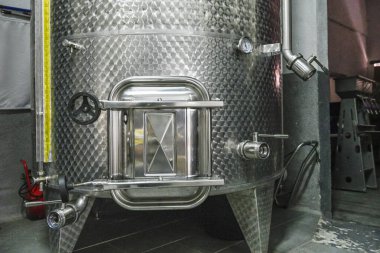 Bir mahzende paslanmaz çelik şarap tankı.