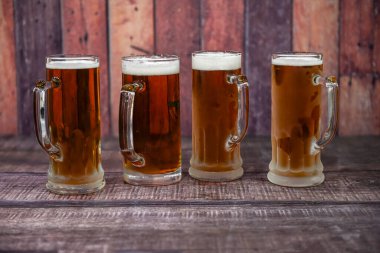 Mug of beer reflected on the table and with the orange background. Copy space