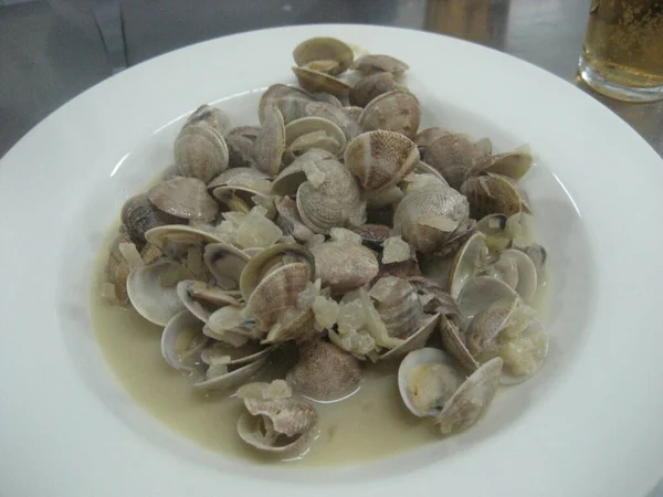 Steamed clams, and served on a white plate