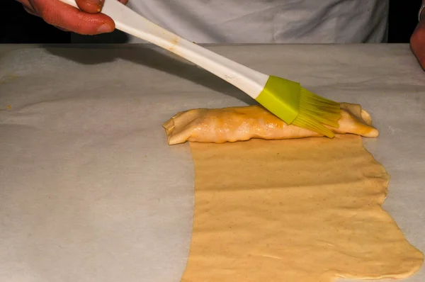 Cover the puff pastry with egg yolk, using a pastry brush