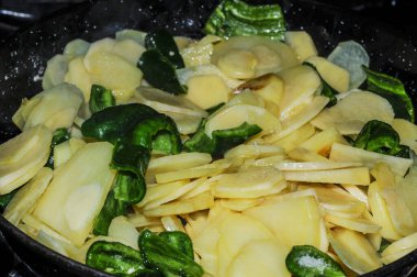 Mutfakta tavada biberli patates kızartmak.