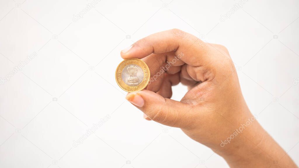 Indian girl showing a head side of ten-rupee coin
