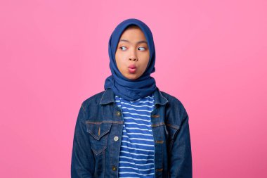 Şok olmuş genç Asyalı kadının portresi pembe arka planda yer almaya çalışıyor.