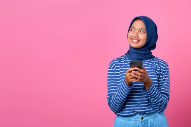 Elinde cep telefonu olan gülümseyen Asyalı bir kadının portresi.