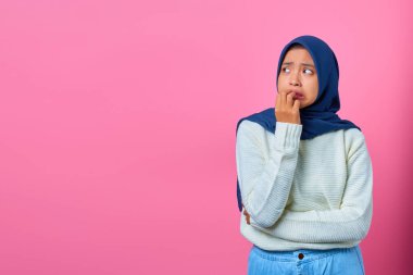 Asyalı genç bir kadının portresi gergin ve gergin görünüyor, elleri ağızlarında, tırnaklarını yiyorlar.