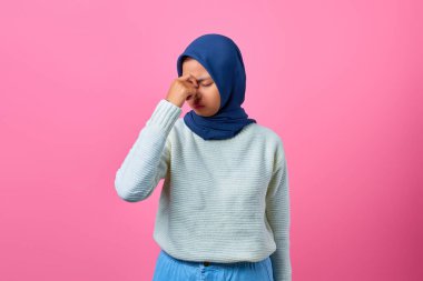 Baş dönmesi ve baş ağrısı çeken Asyalı genç bir kadının portresi. 