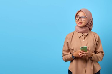 Elinde cep telefonu olan gülümseyen Asyalı bir kadının portresi.