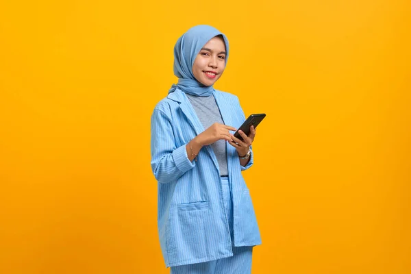 Gülümseyen Asyalı Kadın Cep Telefonu Tutuyor Sarı Arka Planda Izole — Stok fotoğraf