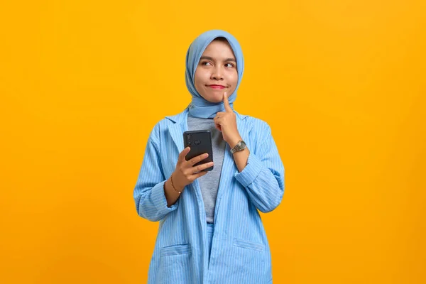 Красивая Молодая Азиатка Пользующаяся Мобильным Телефоном Пальцами Подбородке Желтом Фоне — стоковое фото