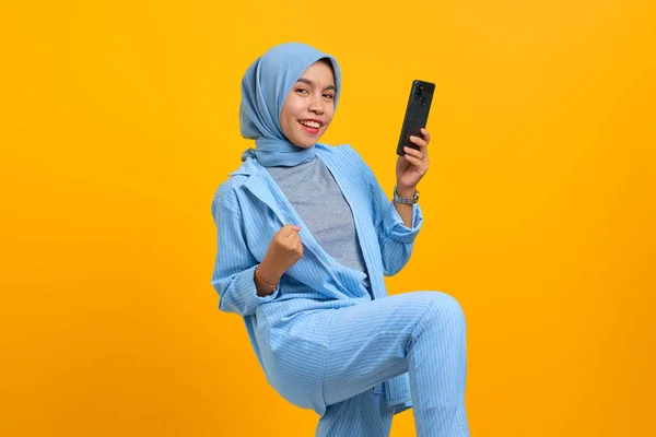 Neşeli Genç Asyalı Kadın Cep Telefonu Tutuyor Sarı Arka Planda — Stok fotoğraf